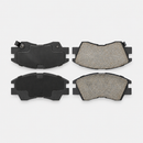 Four ceramic brake pads with dark backing plates and wear indicator tabs
